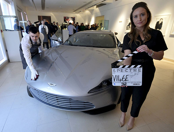 An employee poses as an Aston Martin DB10, one of the series of DB10s designed and engineered by Aston Martin for the James Bond film "Spectre", is polished during a media preview of "Spectre - the Auction", at Christie's auction house in London February 15, 2016. REUTERS/Hannah McKay